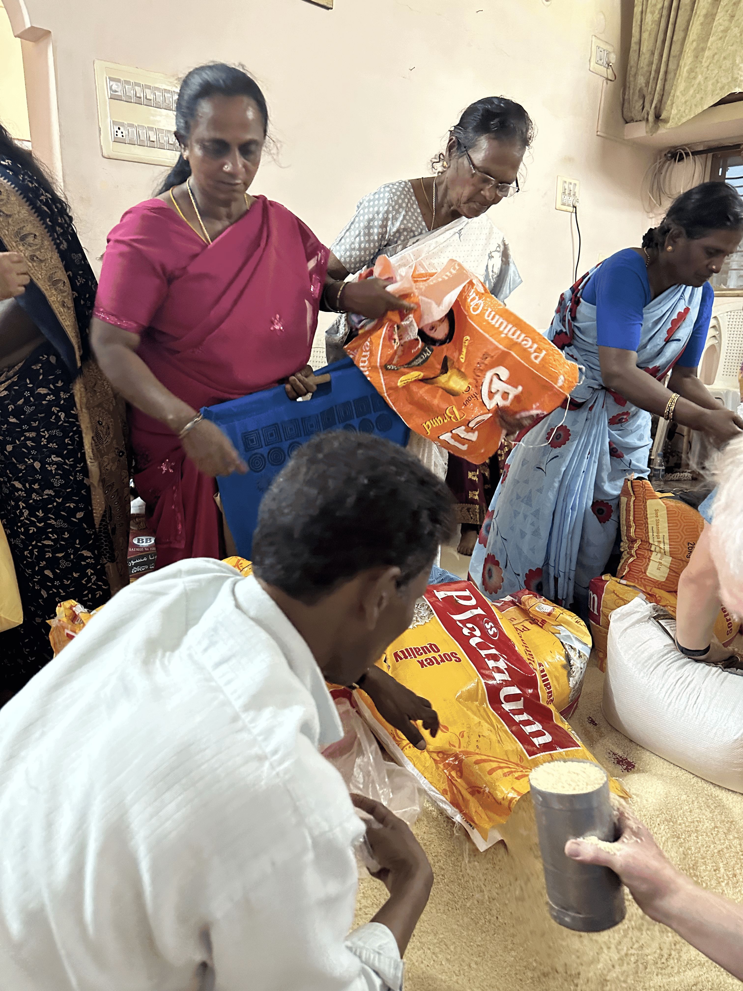 Widows in India receiving rations of rice, lentils, and oil